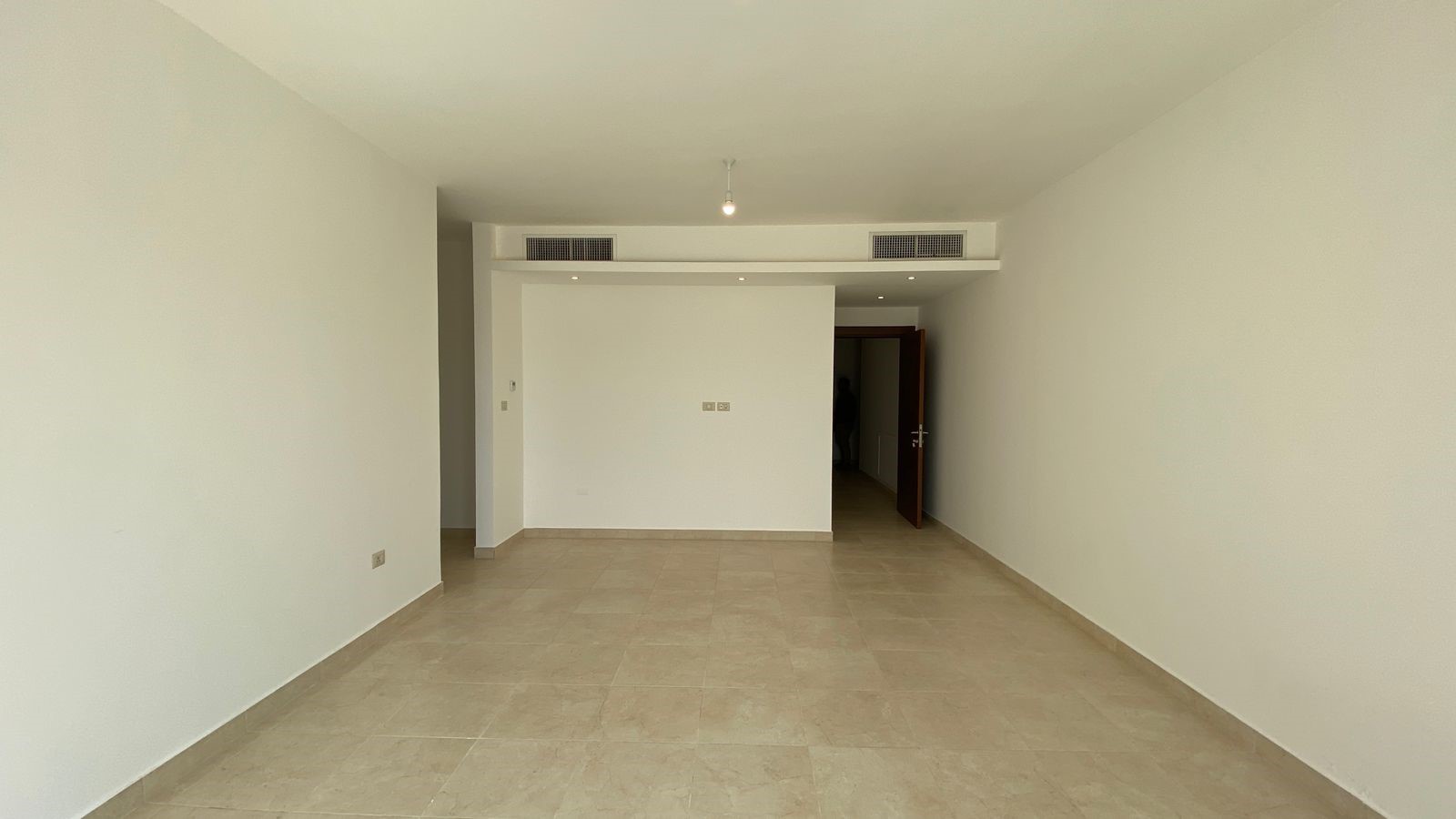 0d5ae128-bacd-4e32-8753-4841ac9b58c2 Empty modern room with beige tile floor, white walls, and a doorway at the far end.