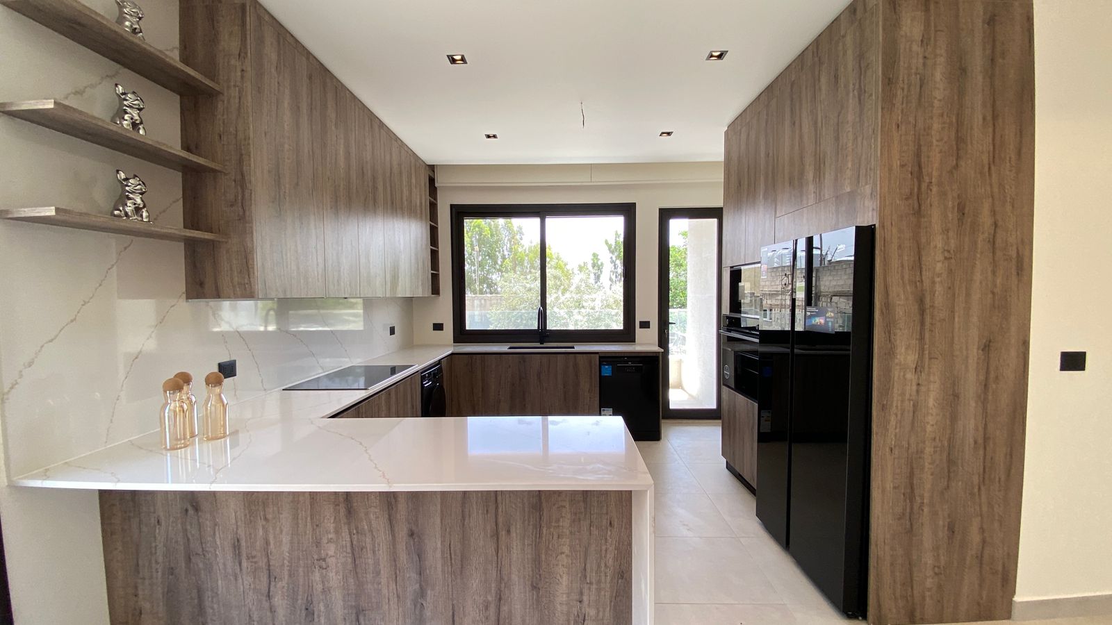 3623f697-59b3-4717-9e27-7265ff058745 Modern kitchen with wood veneer cabinets, white veined countertops, and a center island.