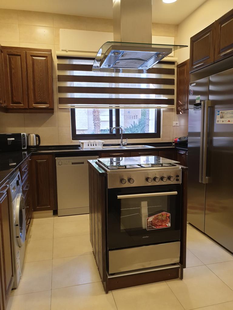 6ce8db90-2404-4a99-887d-e668e5c8f0c3 Modern kitchen with stainless steel oven on a central island and a glass-range hood above it.