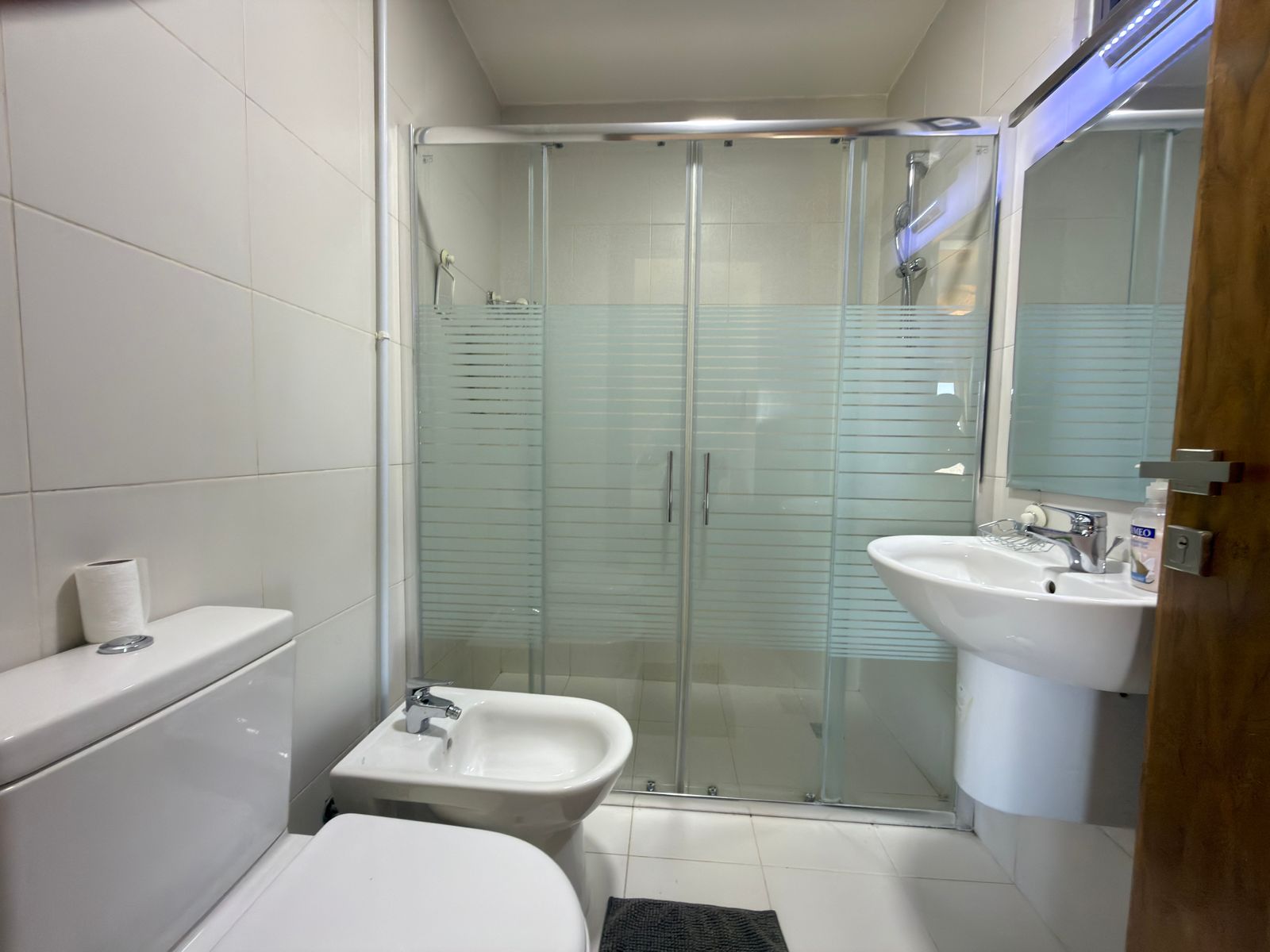 c1269b92-6944-4c59-9adc-98d0761ef2c1 Small contemporary bathroom with toilet, bidet, sink and a frosted-glass shower enclosure with sliding doors