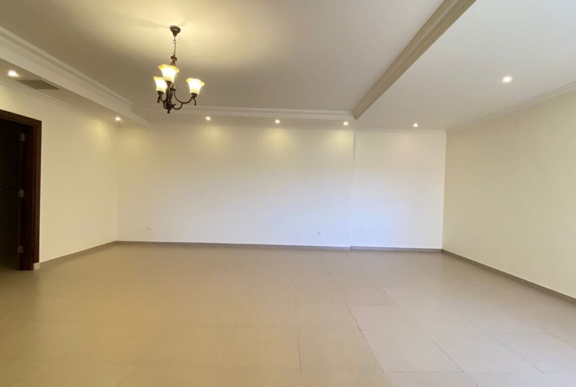 14d46f91-ab4f-4371-9177-831bd3c5b06e Empty, spacious living room with beige tile floor, cream walls, crown molding, and a hanging chandelier as focal point.