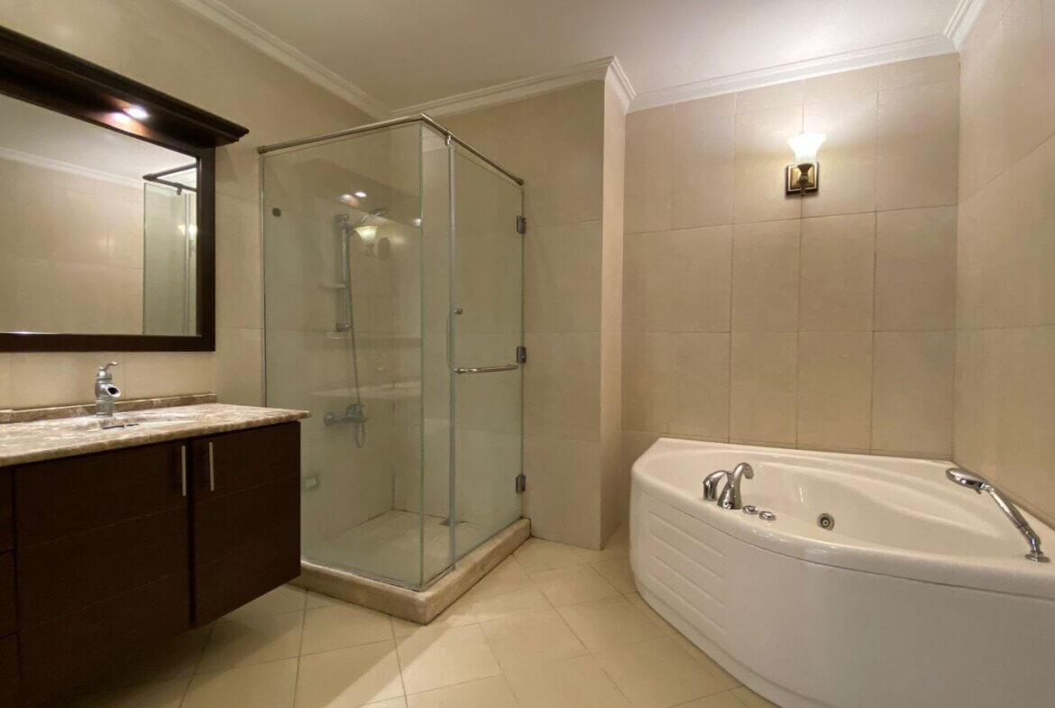 5eedd28a-3e76-4147-b42b-1afdab112881 Modern bathroom with glass-enclosed shower, dark wood vanity, and a corner jetted tub.