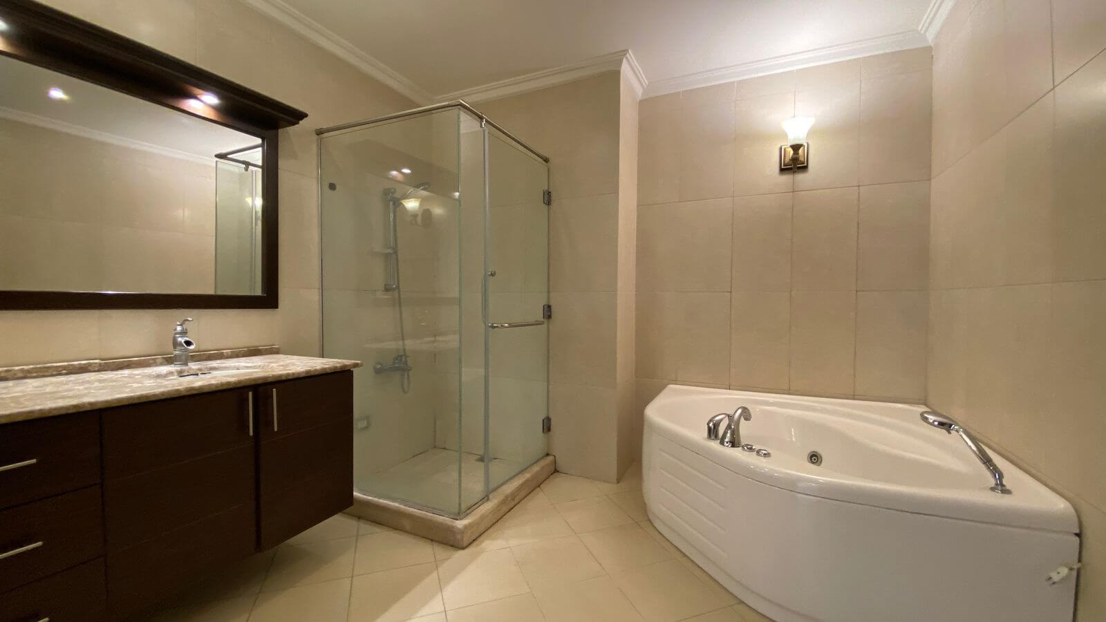 5eedd28a-3e76-4147-b42b-1afdab112881 Modern bathroom with glass-enclosed shower, dark wood vanity, and a corner jetted tub.