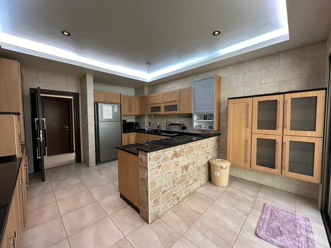b2479b82-28b2-4e38-bb5a-d7d76147c8a8 Modern kitchen with a stone-front island, wooden cabinets, and stainless steel appliances
